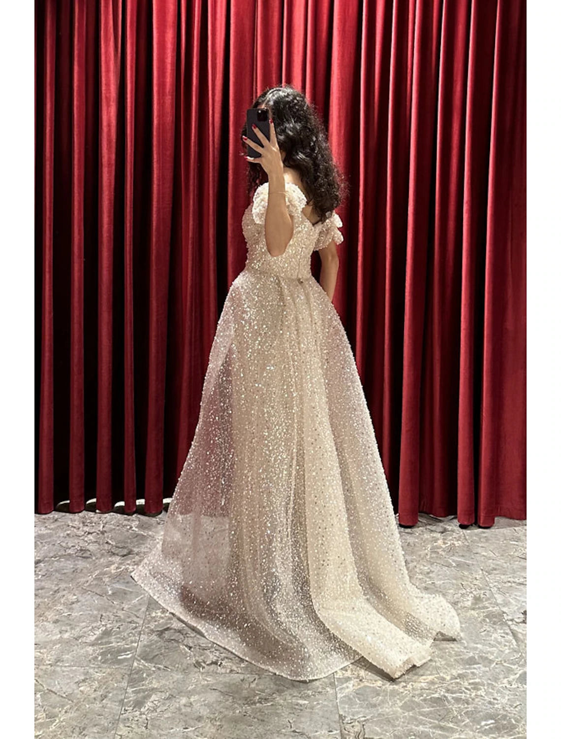 Close-up of the sequined fabric and ruched detailing on the sparkling evening gown.