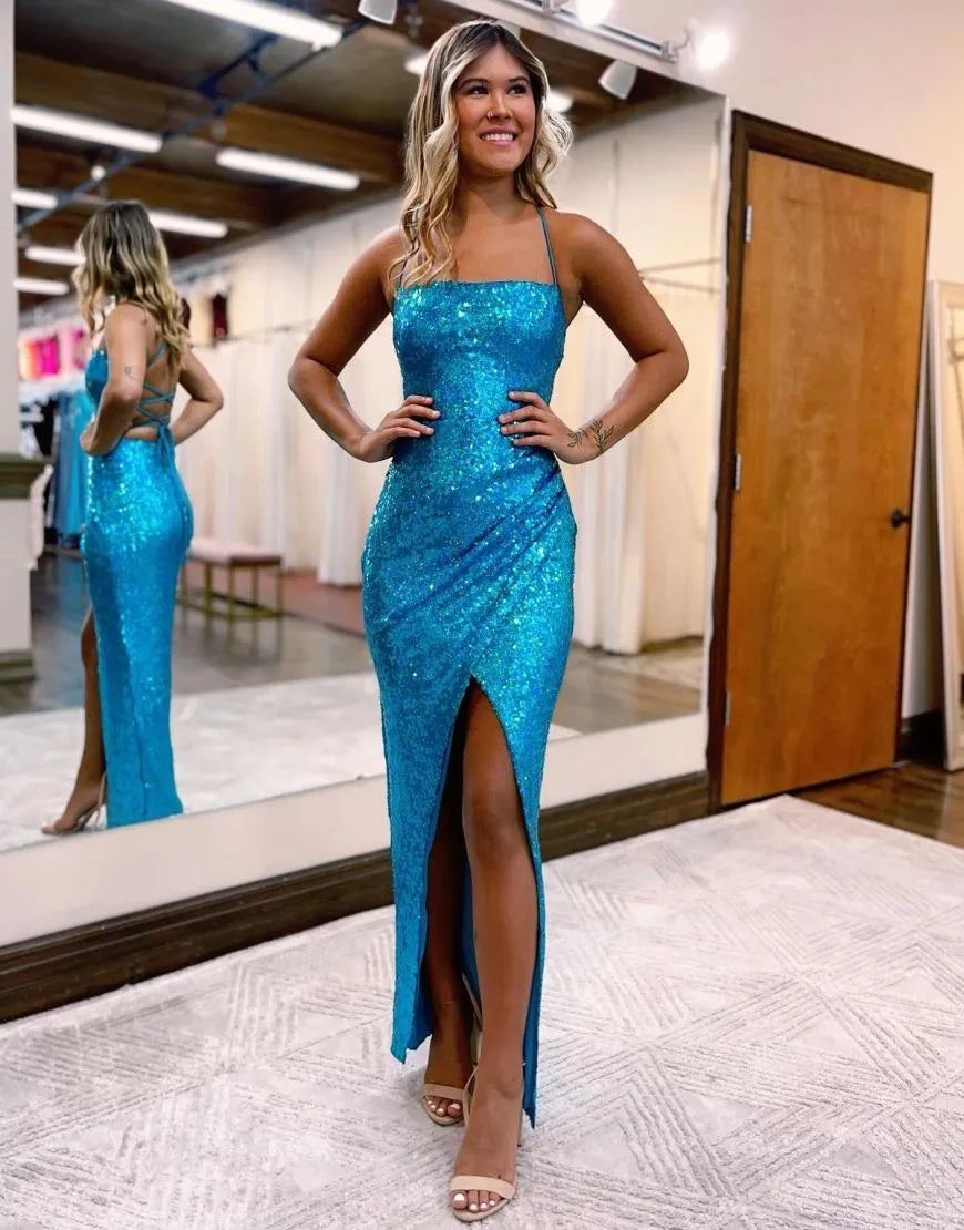 Model wearing a sparkling spaghetti strap sequin prom dress with a corset back and front split.