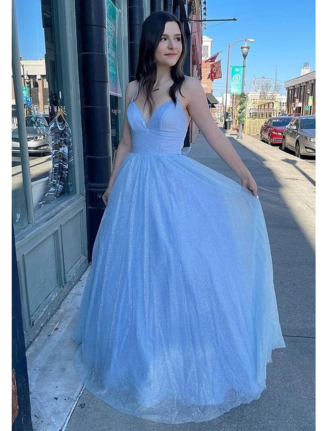 Back view of sparkling A-line ball gown showing backless design and pleats.