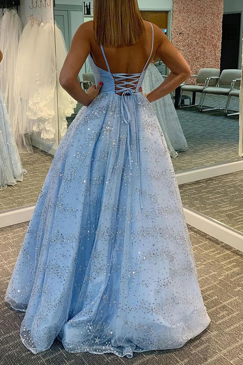 Back view of a model in a sparkling tulle prom dress, showcasing the flowing long skirt.