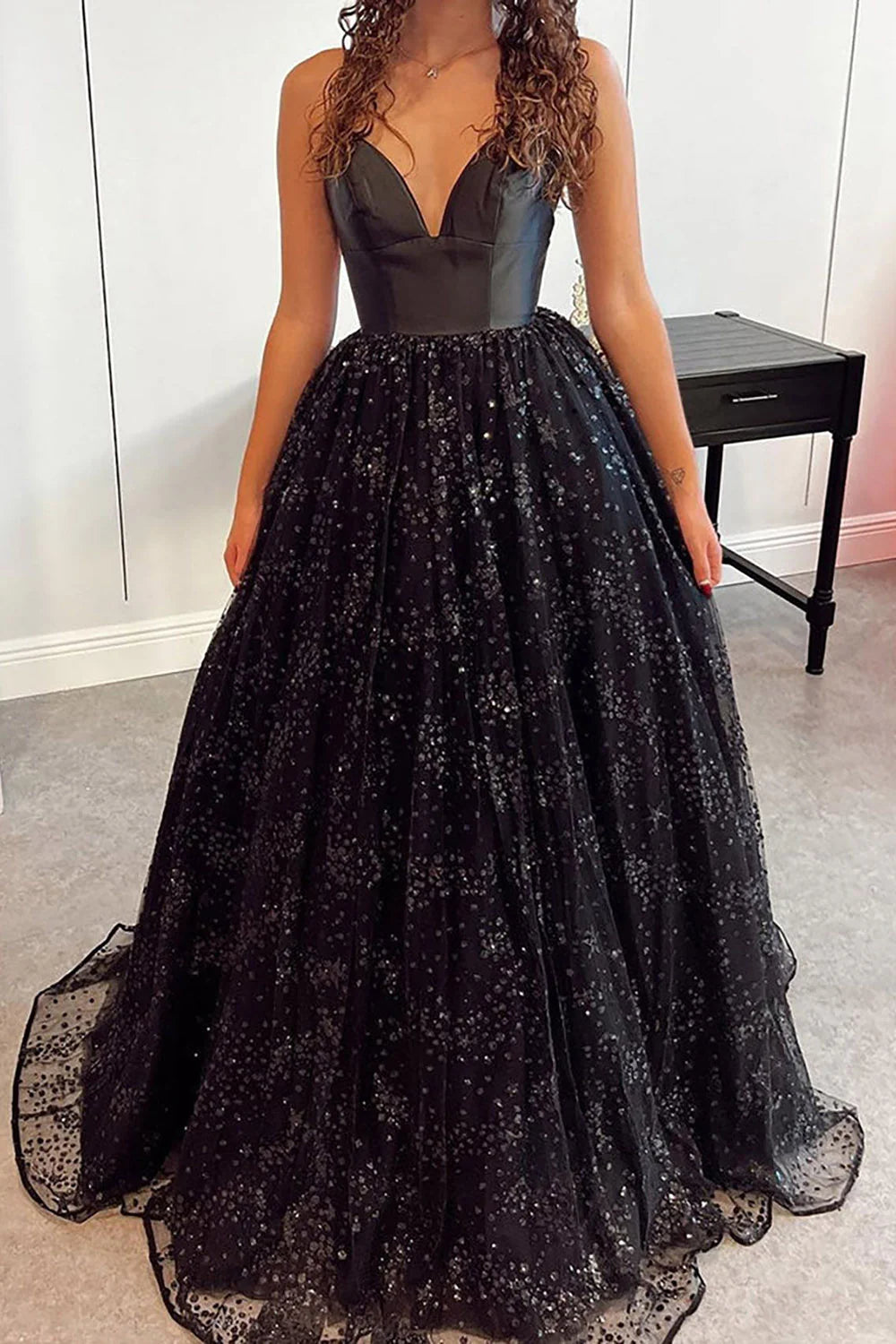 Close-up of the sparkling details on a tulle prom dress with spaghetti straps.