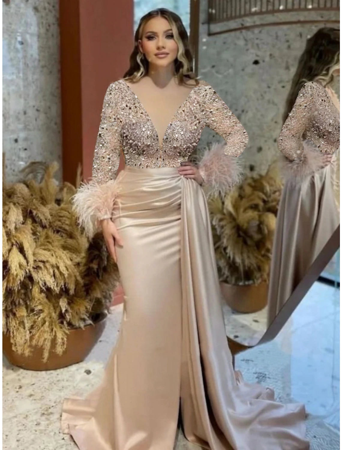 Full view of a sparkling mermaid trumpet evening gown with long sleeves and V-neck.