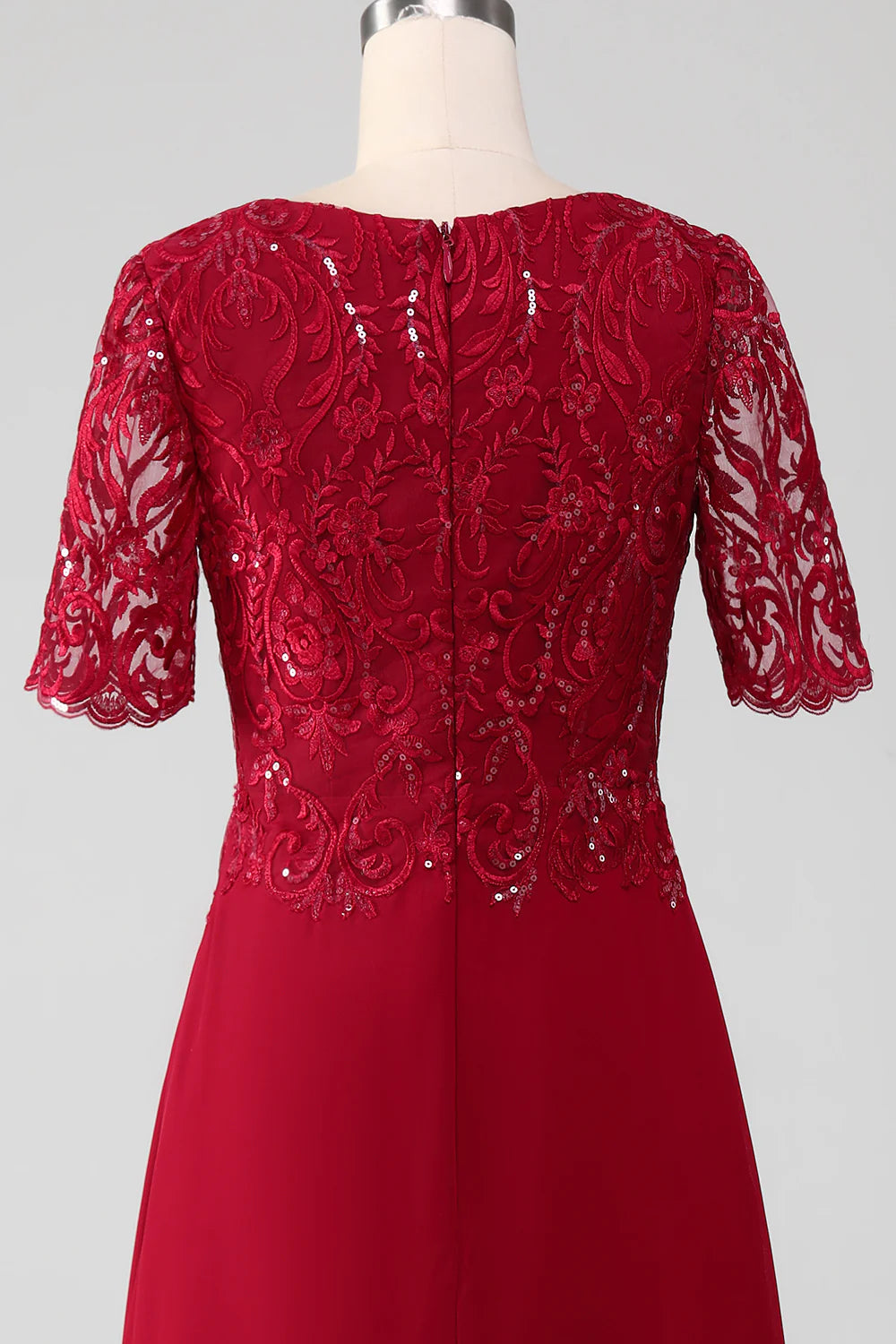 Elegant burgundy sequin gown with floral appliques.