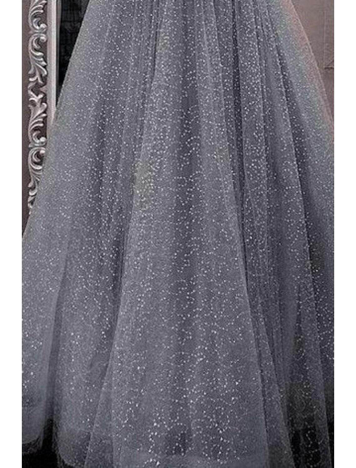 Elegant evening gown featuring glitter crystals and tulle fabric.