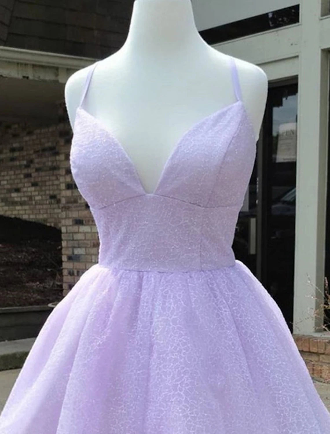 Side view of a sparkly A-line mini homecoming dress, showcasing lace and glitter details.