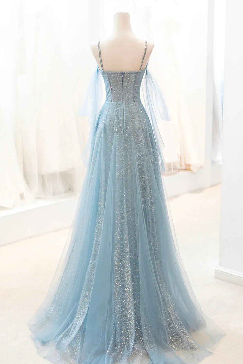 Back view of a model in a sparkly A-line tulle prom dress.
