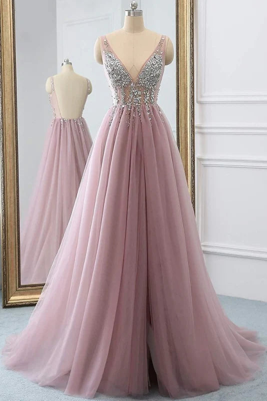Model wearing a sparkly A-line tulle V-neck long prom dress with rhinestones.