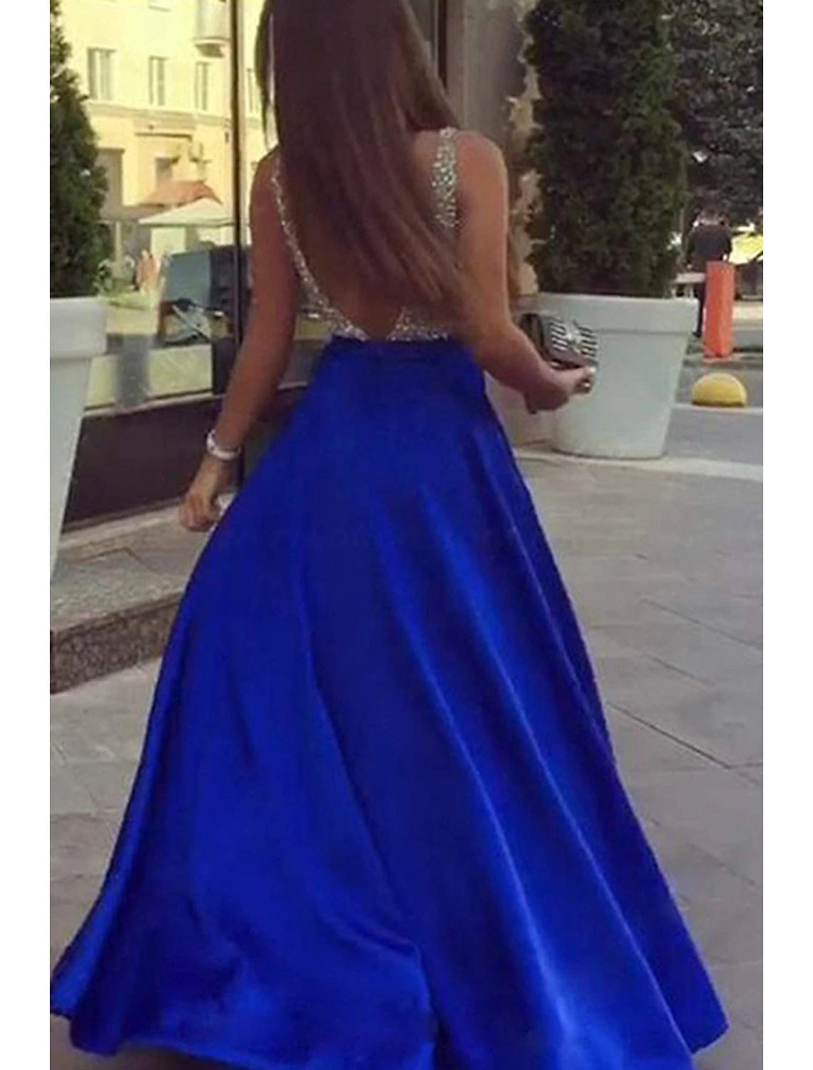 Model showcasing the elegant backless V-back design of the sparkly A-line prom dress.