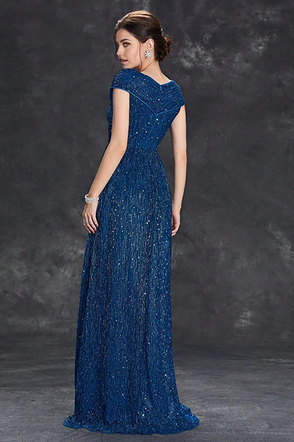 Back view of a woman in a sparkly A-line V-neck long formal dress.