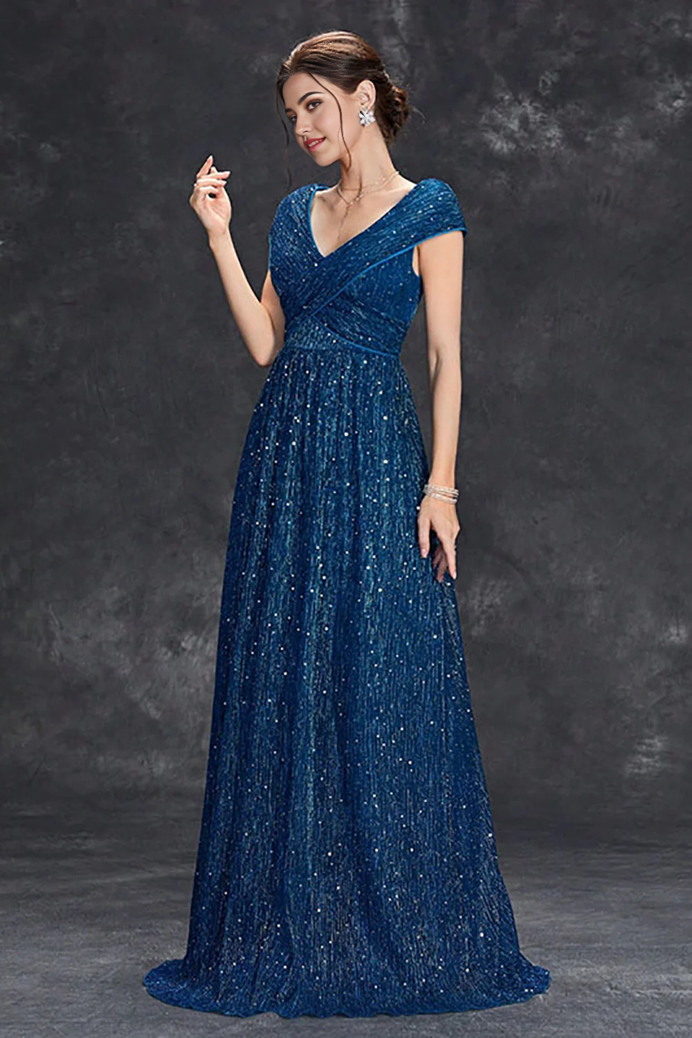 Side view of a woman in a sparkly A-line V-neck long formal dress.