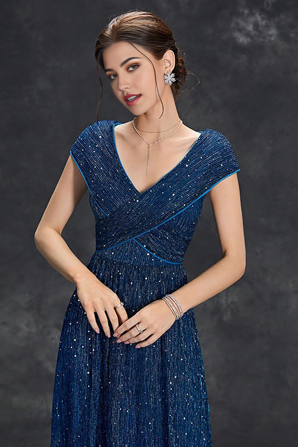 Woman posing in a sparkly A-line V-neck long formal dress.