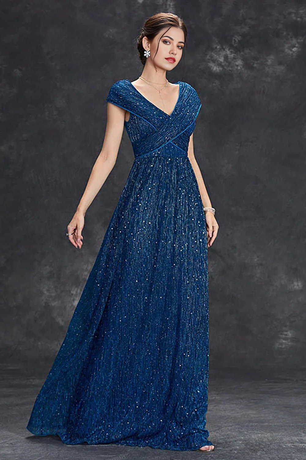 Detailed view of the V-neckline and sparkling material of the formal dress.