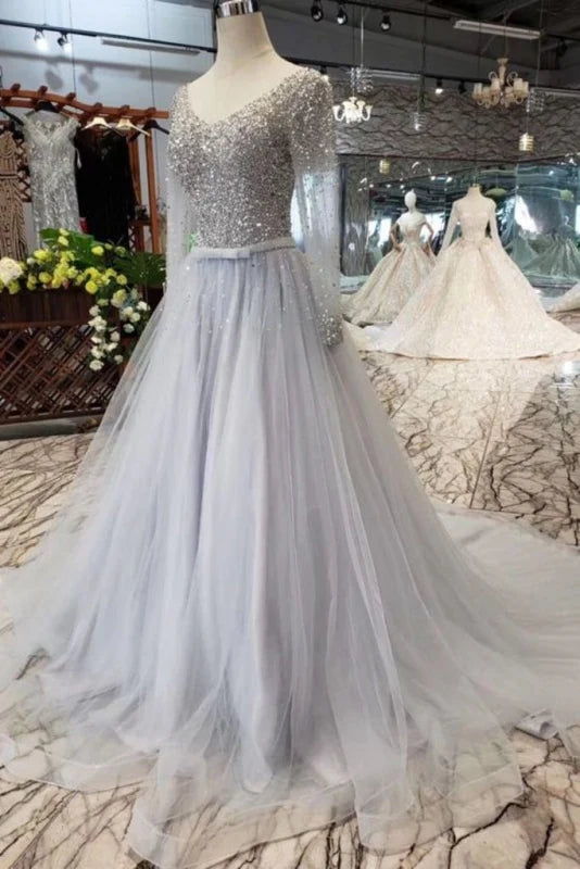 Full view of a sparkly A-line V-neck long sleeve prom dress.
