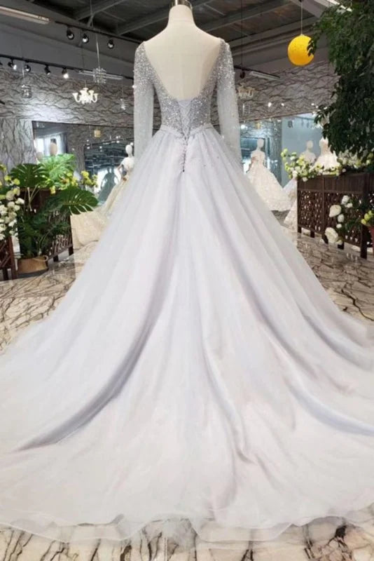 Close-up of the V-neckline and long sleeves with sequin details on the dress.