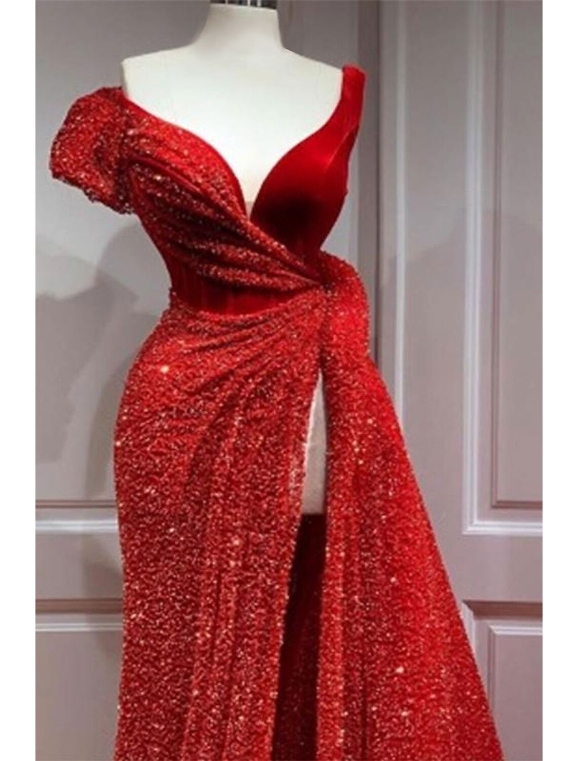 Side view of a satin formal evening gown with a flowing court train and sequin details.