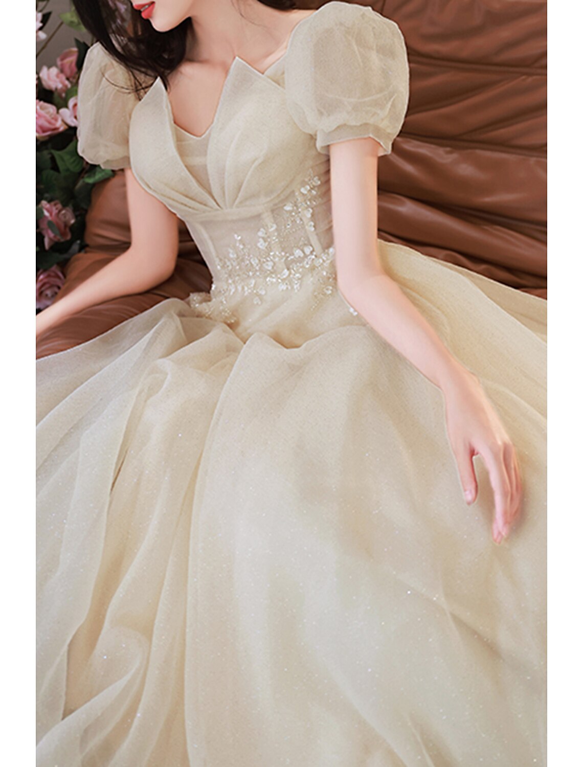 Close-up of sequin and tulle fabric detail on a V-neck prom dress.