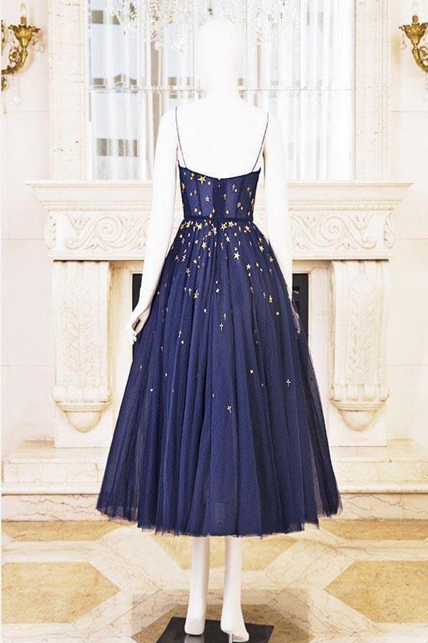 Model wearing a sparkly A-line short homecoming dress with star embellishments.