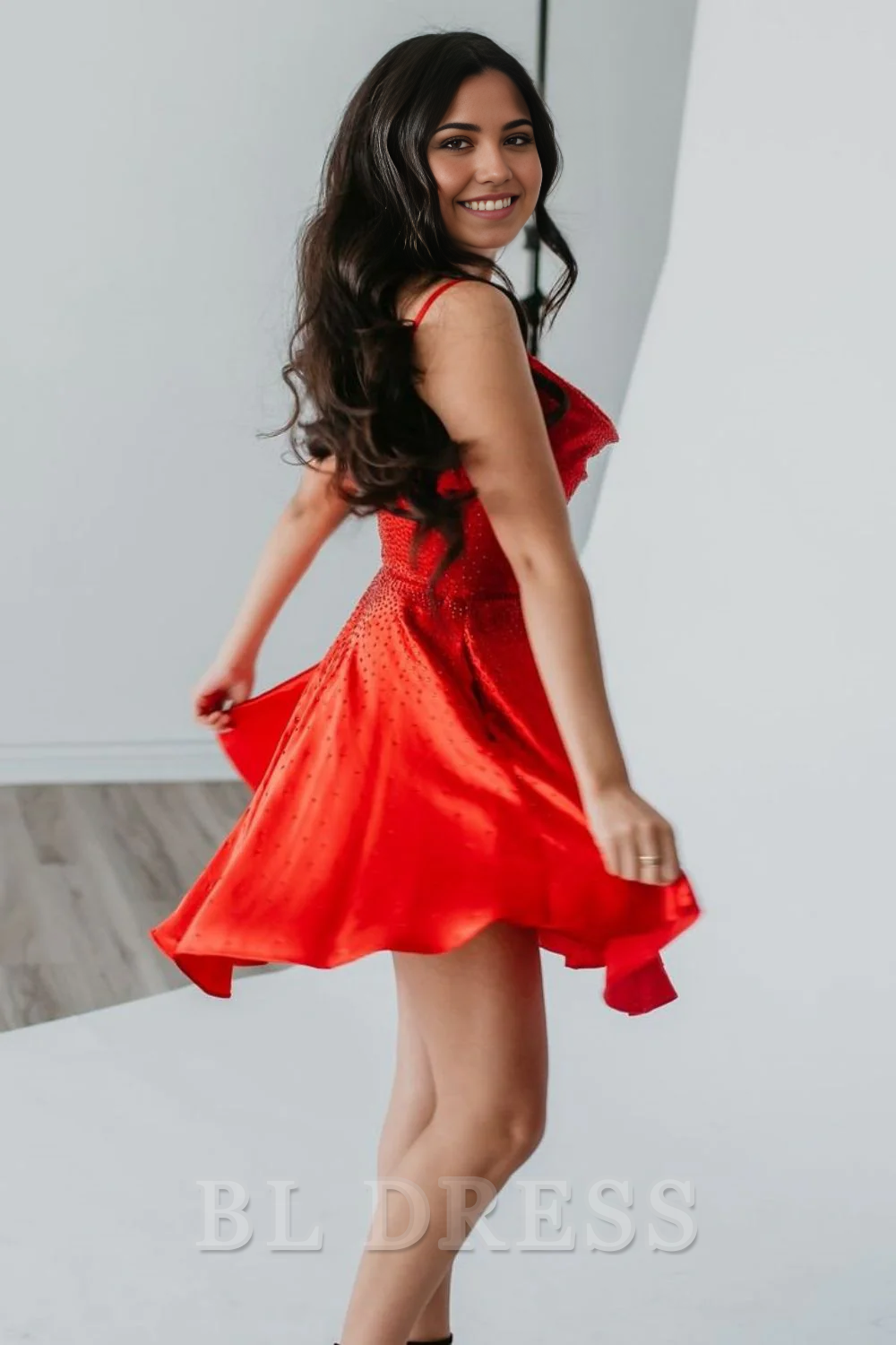 Back view of a woman in a short red A-line formal dress with delicate spaghetti straps.