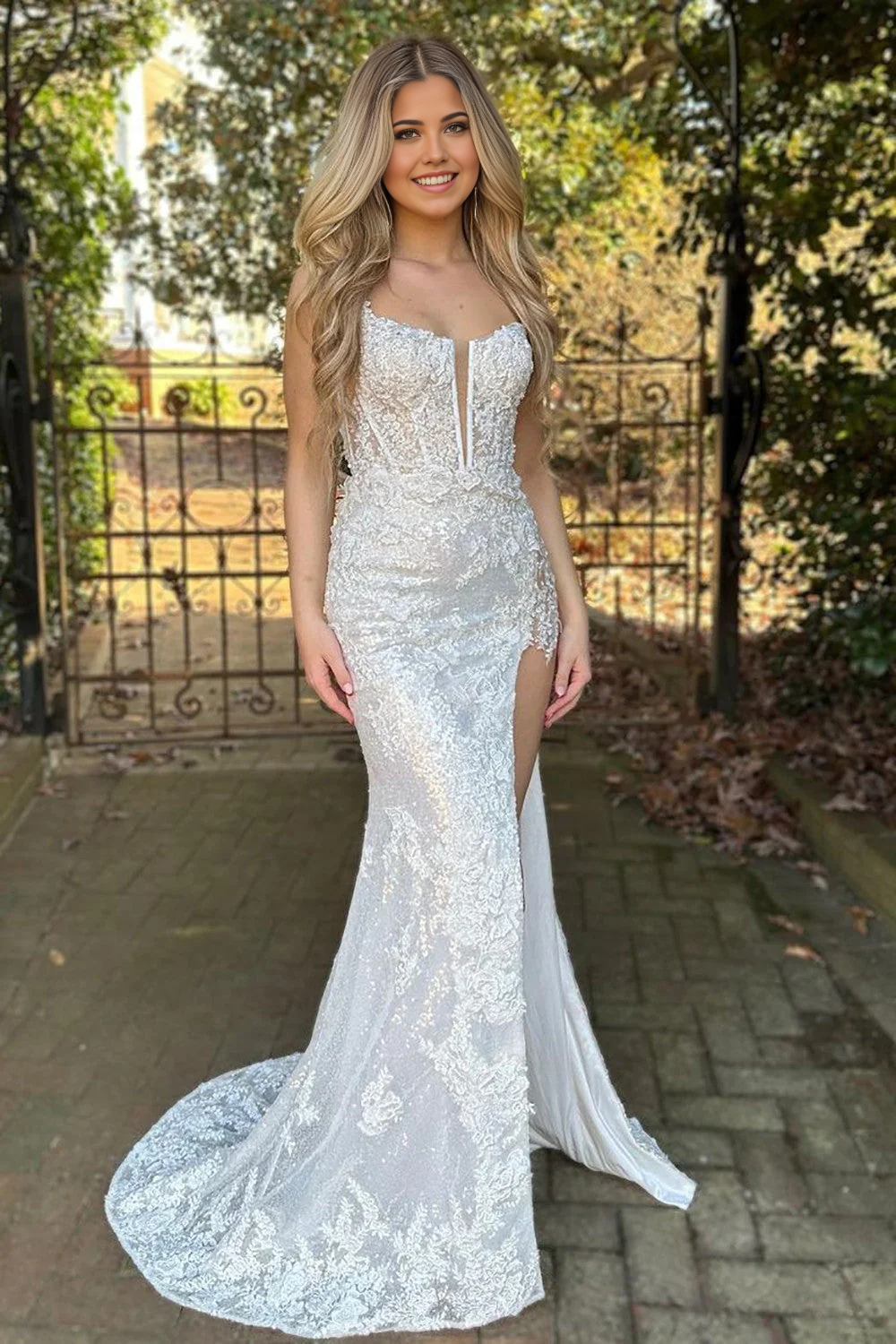 Full view of a sparkly A-line prom dress with spaghetti straps and a high split.