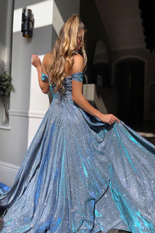 Model posing in a sparkly A-line prom dress with a high slit.