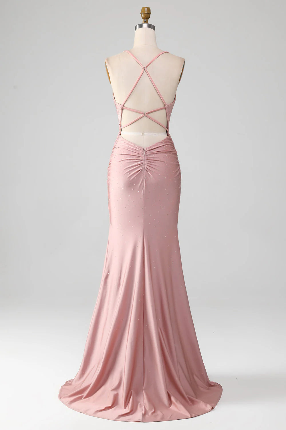 Back view of a woman wearing a blush pink sparkly mermaid prom dress.