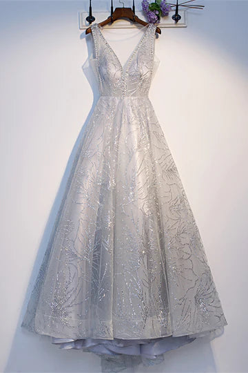 Model wearing a sparkly A-line deep V-neck tea length formal dress.