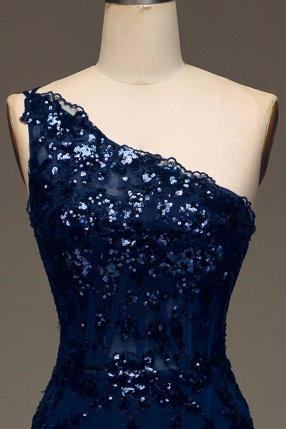 Close-up of the sparkly lace fabric and high slit on the dark navy prom dress.