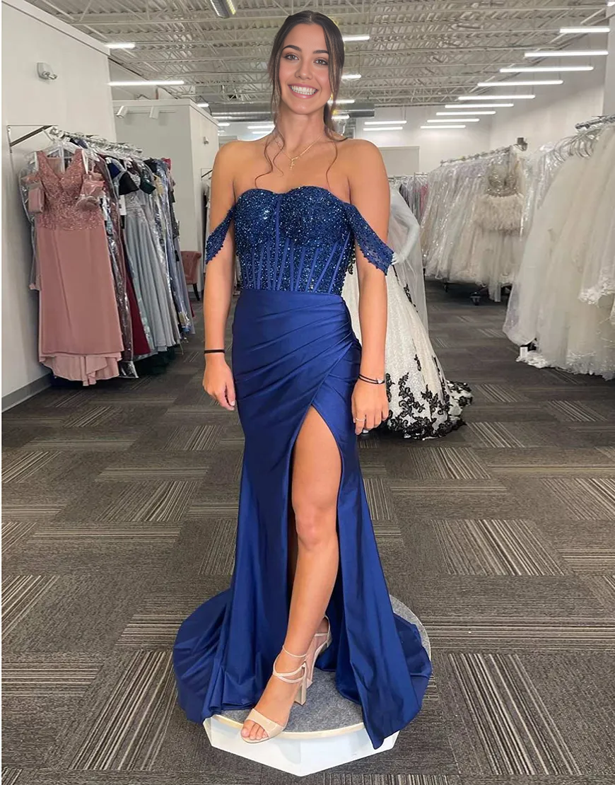Woman wearing a sparkly navy mermaid off-shoulder formal dress with a high slit.