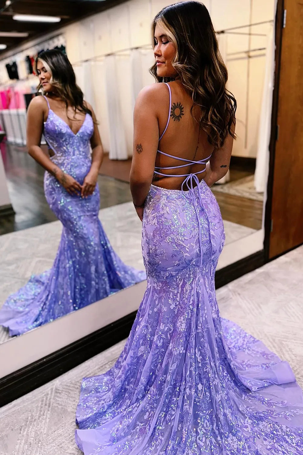 Side view of a woman in a sparkly mermaid sequin prom dress, highlighting the silhouette.