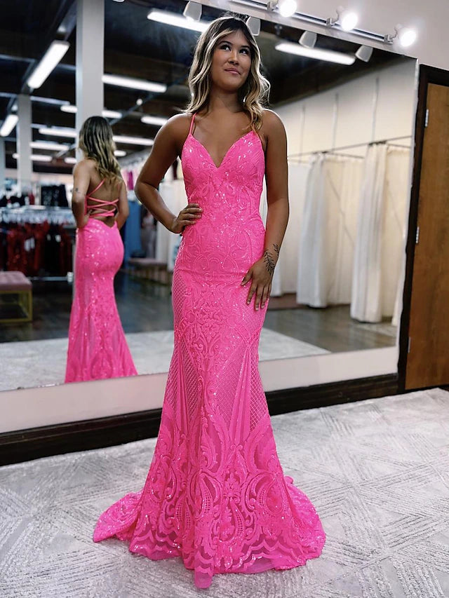 Side profile of an elegant V-neck sequined prom gown with a sweep train.