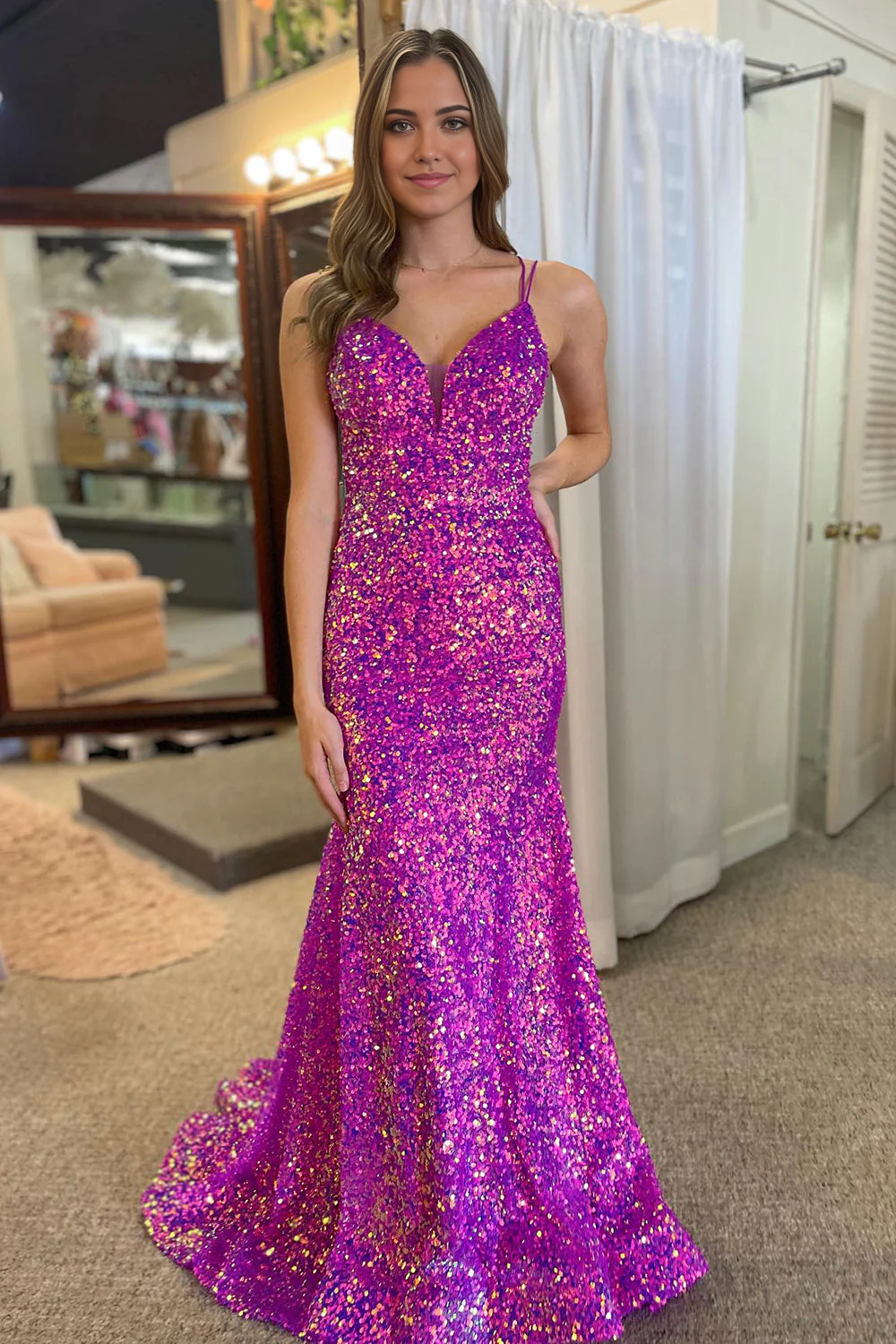 Front view of a woman wearing a sparkly purple mermaid prom dress with double straps.