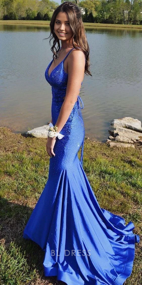 Model in a sparkly royal blue mermaid V-neck long prom gown.