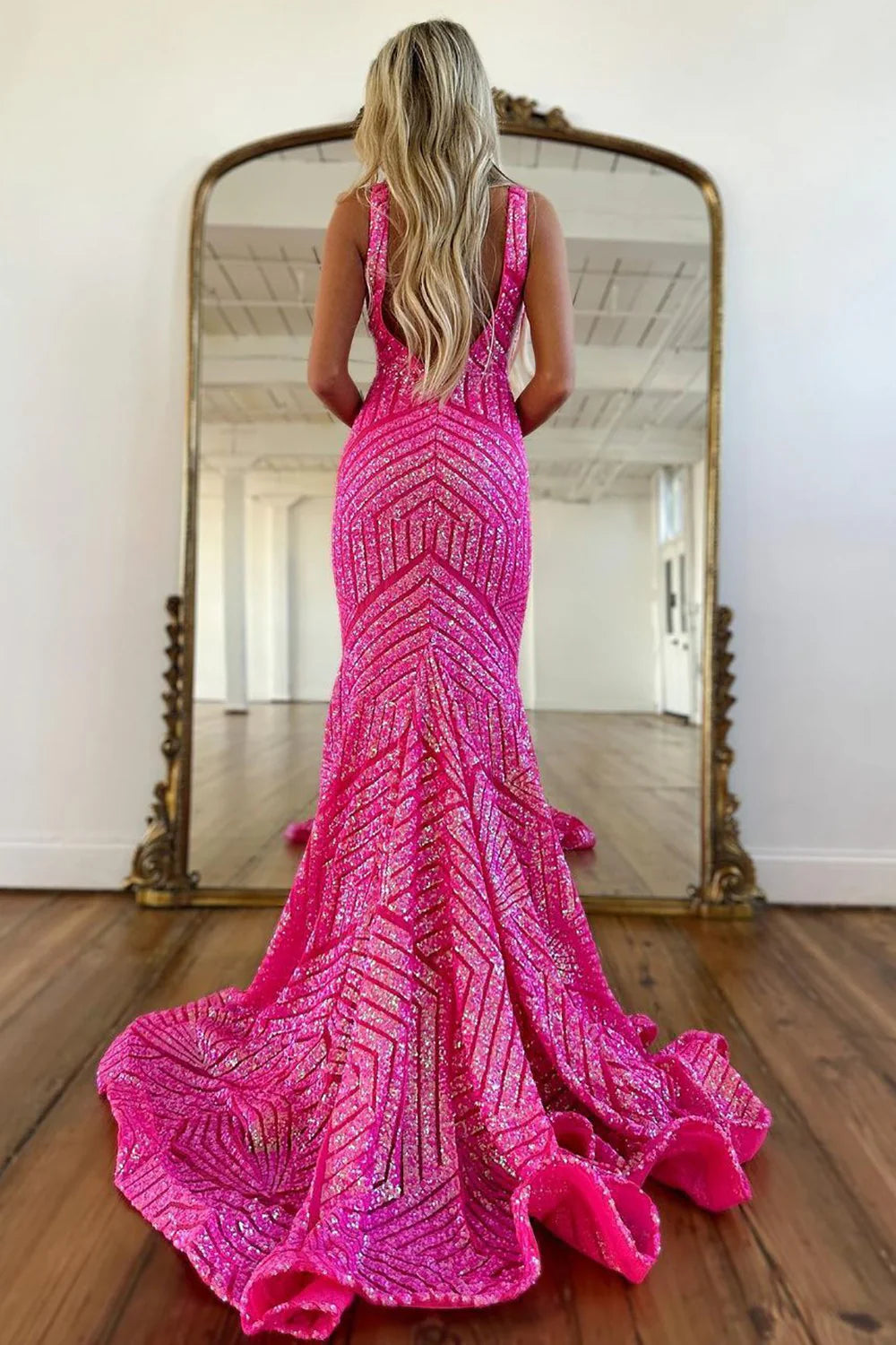 Back view of a sparkly mermaid V-neck sequin formal gown.