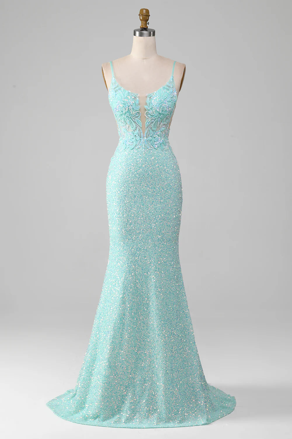 Woman wearing a light green sparkly mermaid sequin prom dress with a high slit.