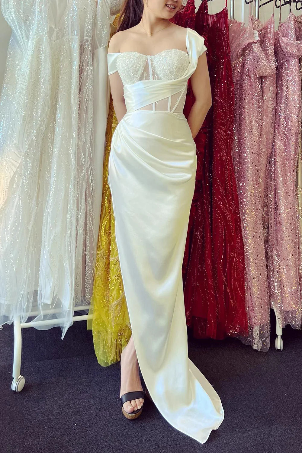 Model wearing a sparkly off-shoulder corset prom dress, full length view.