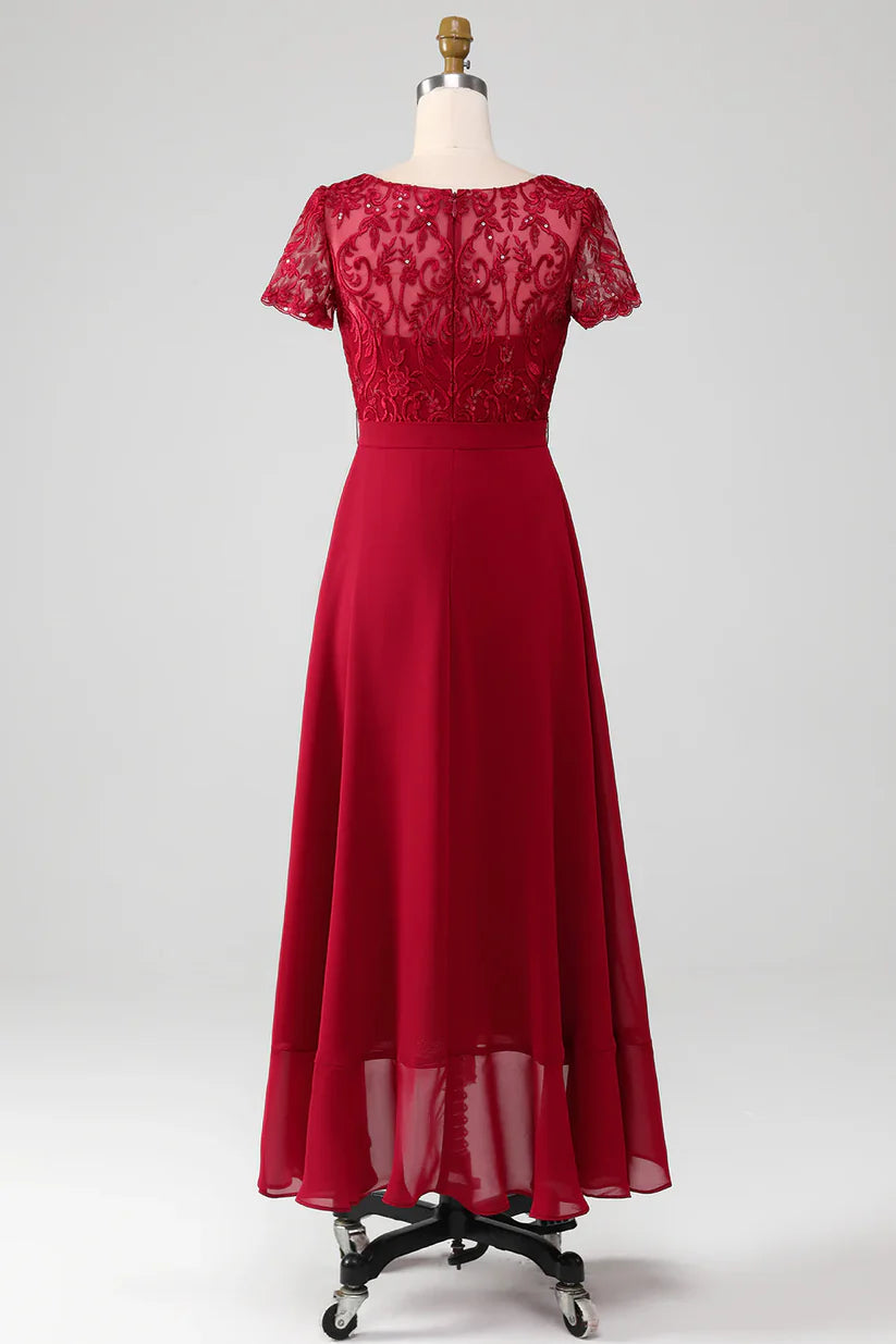 Close-up of the sparkly sequin fabric and applique details on the asymmetrical Mother of the Bride dress.