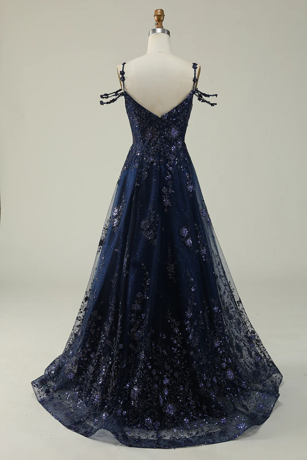 Back view of a woman wearing a navy sparkly sequin ball gown dress.