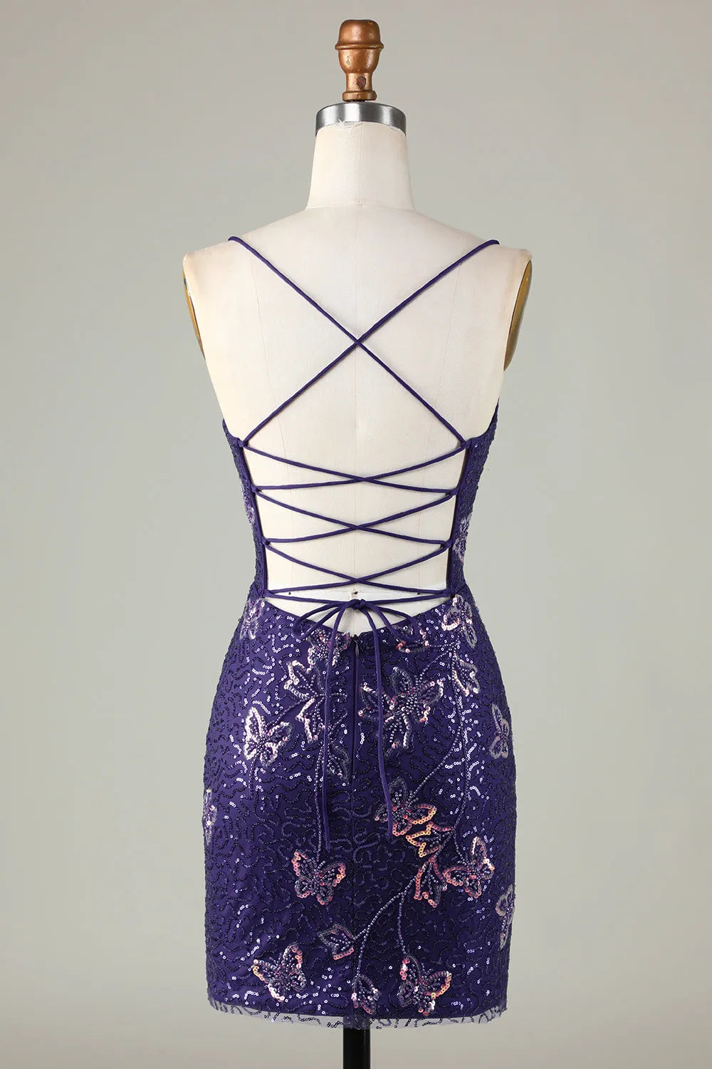 Back view of a sparkly silver sequin sheath dress, showing criss cross straps.