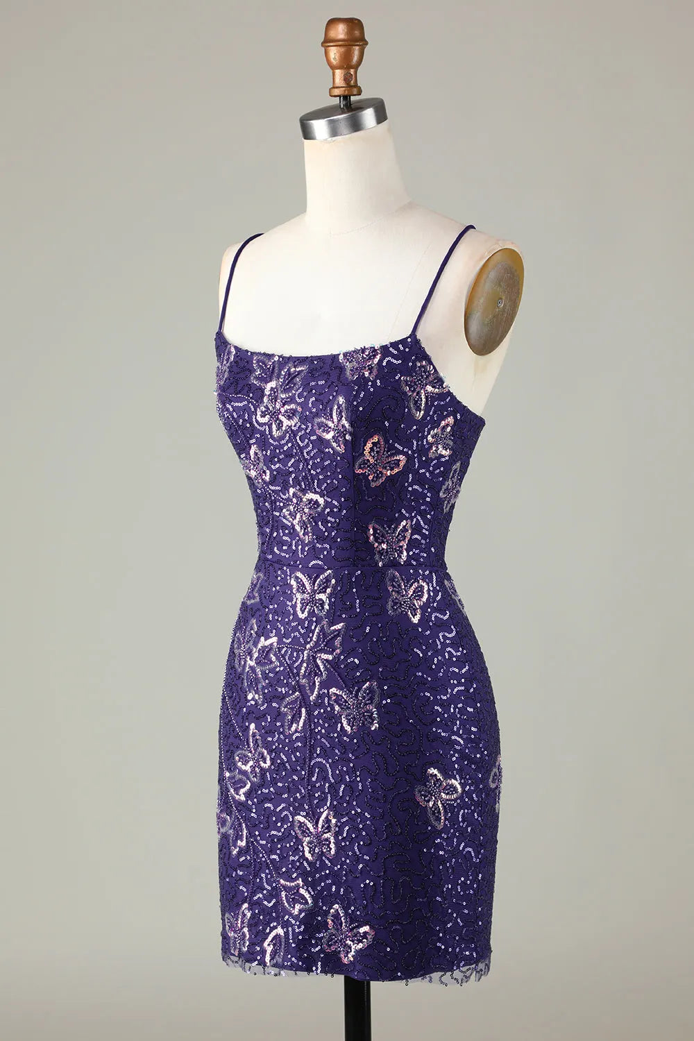 Side profile of a model in a short sparkly silver sequin sheath dress.