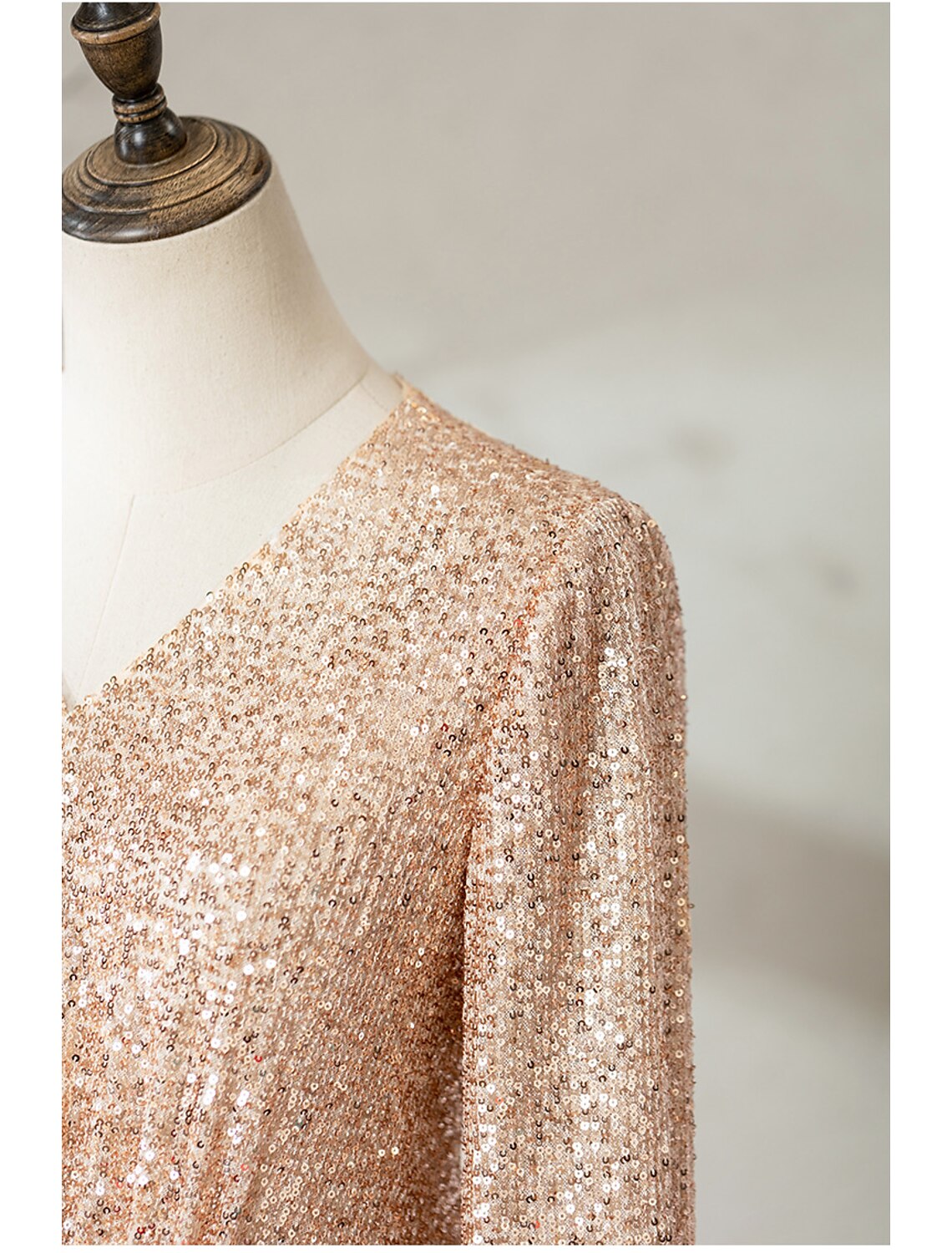 Side view of a woman posing in a sequined V-neck half sleeve gown.
