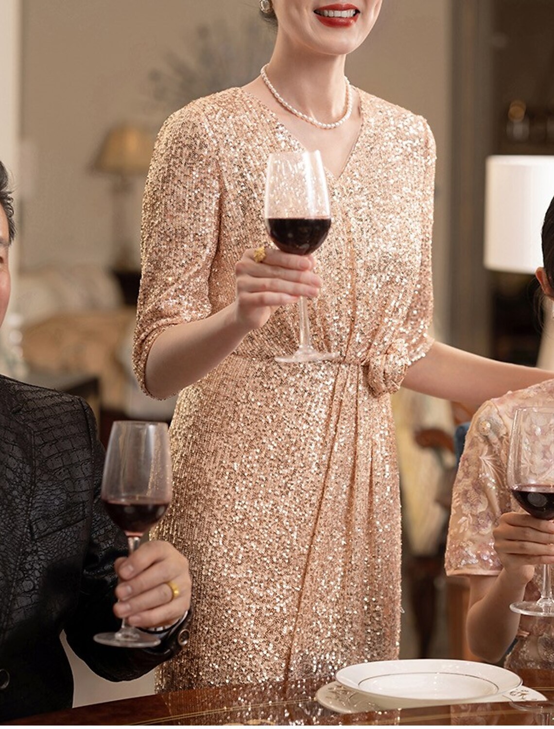 Woman showcasing the flow and sparkle of the sequined floor length dress.