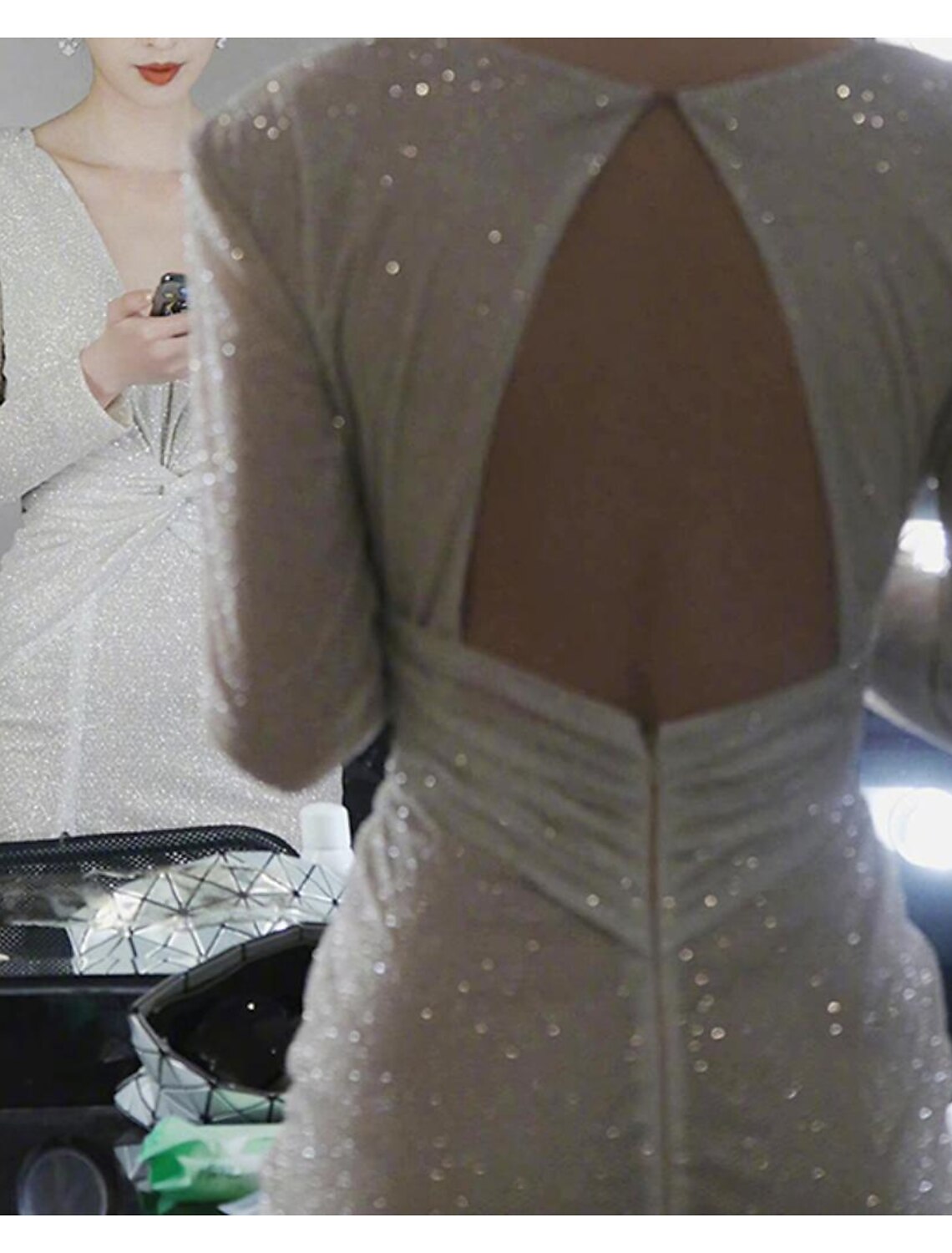 Close-up of the sequin embellishments and elegant slit on the dress.