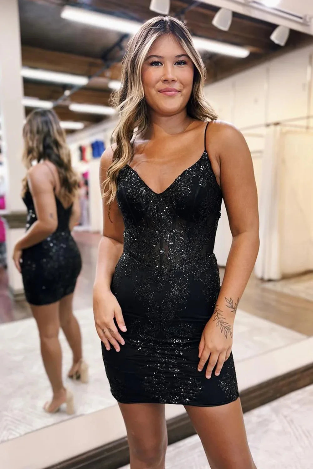 Model in a sparkly short prom dress with spaghetti straps.