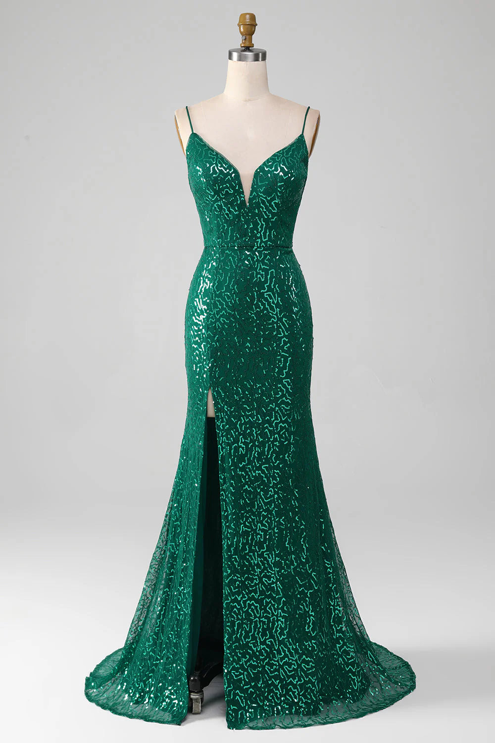 Model wearing a sparkly dark green V-neck long prom dress with a high slit.