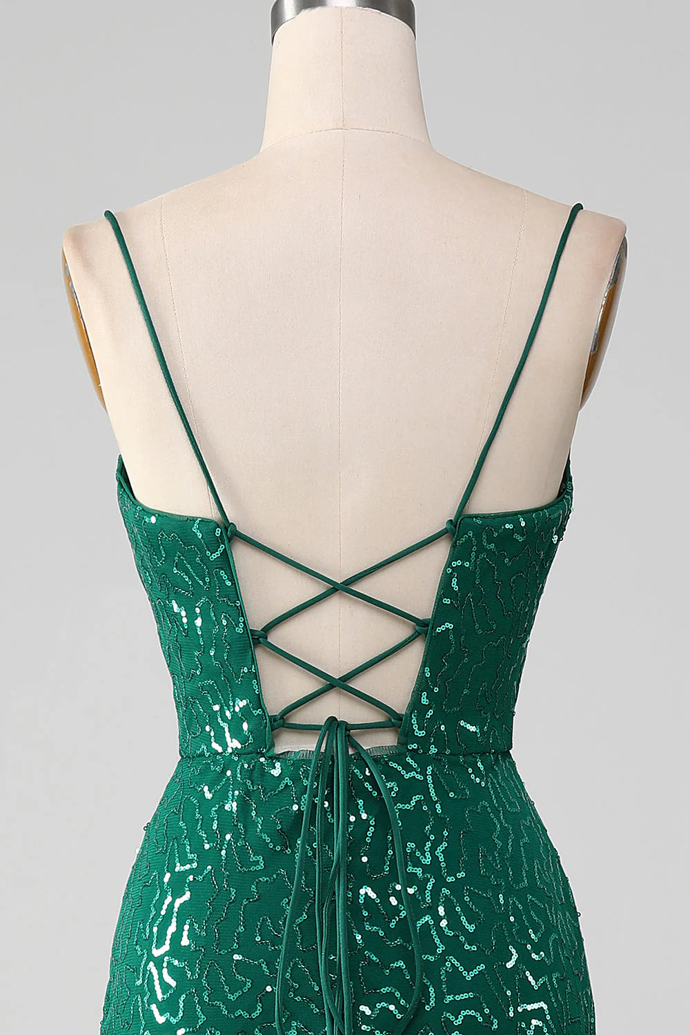 Side view of a model showcasing the elegant slit of the dark green prom dress.
