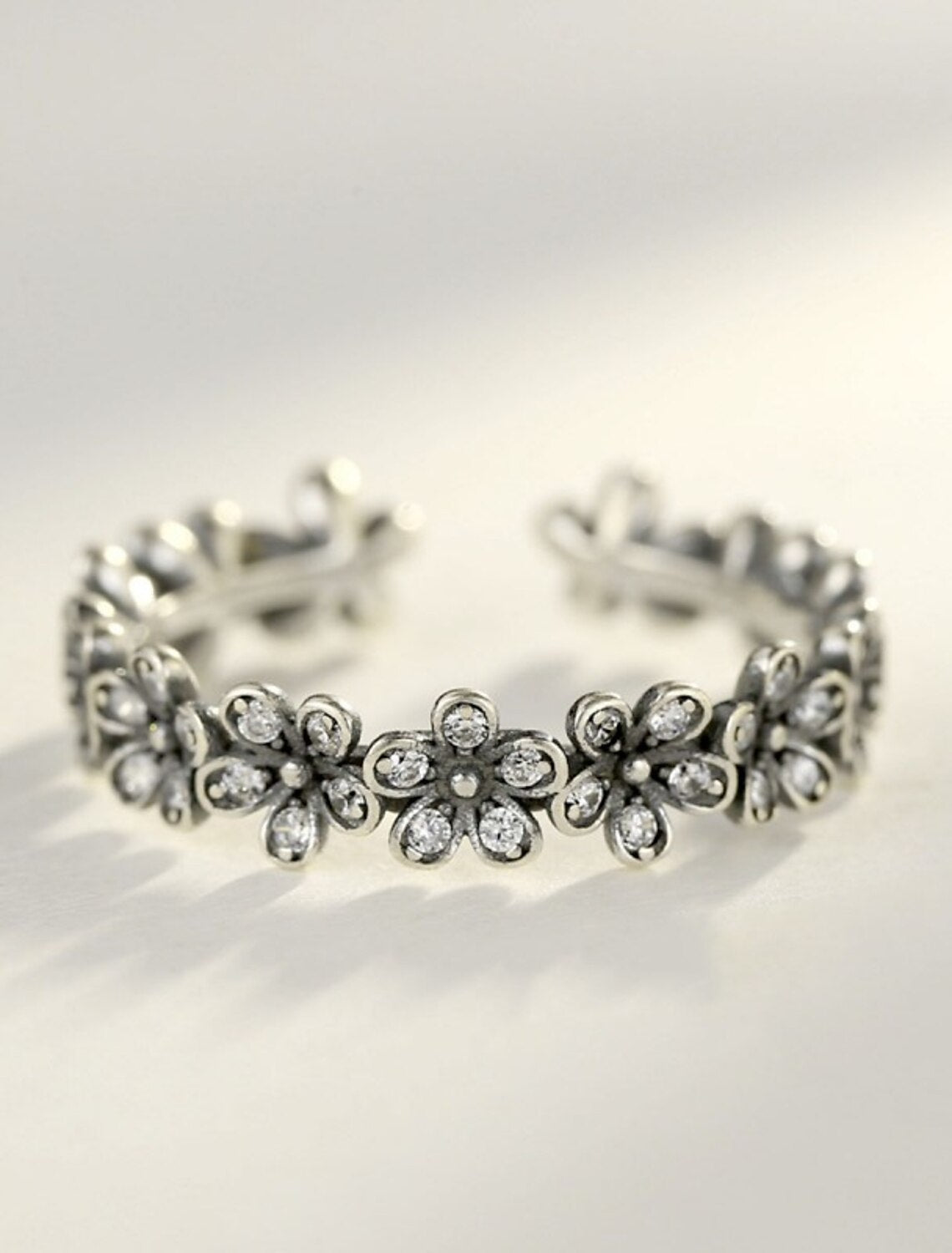 Close-up of sterling silver flower zircon open ring.