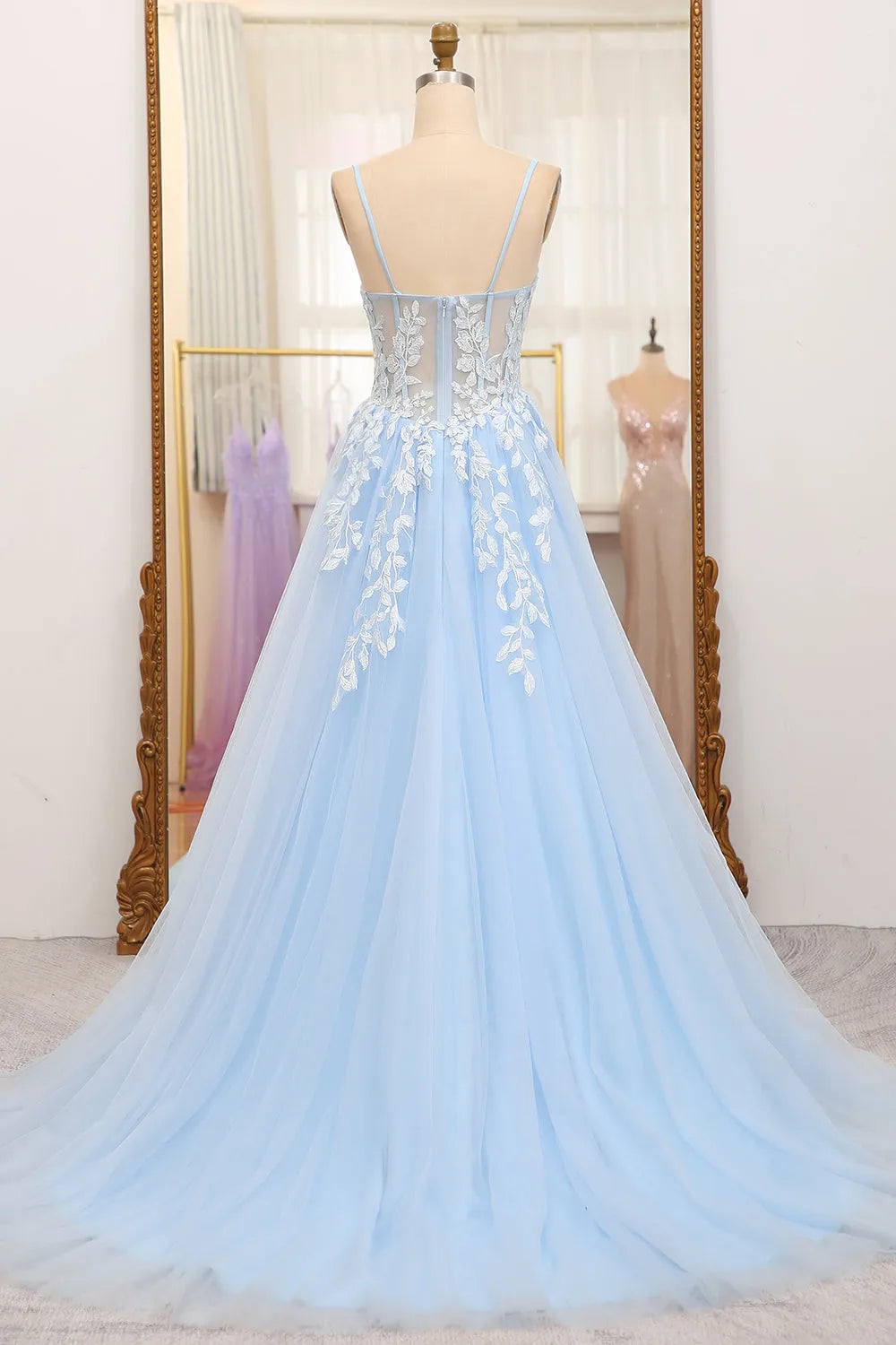 Close-up of the bodice of a sky blue A-line prom dress, showing appliques and spaghetti straps.