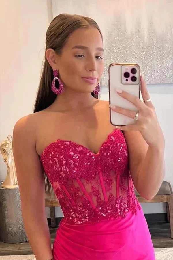 Elegant hot pink mermaid prom dress showcasing lace appliques and side slit detail.