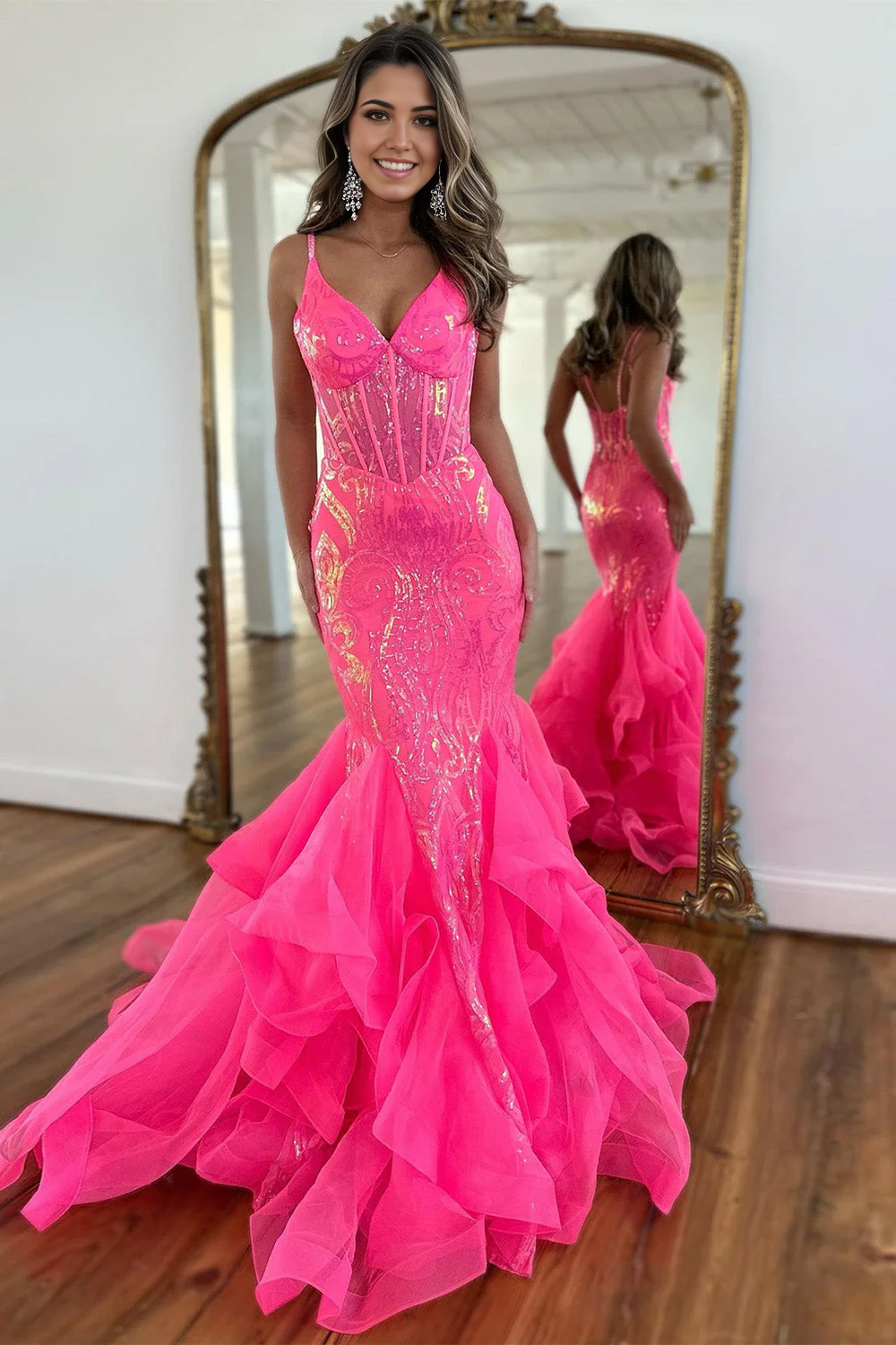 Full view of a hot pink sequin mermaid prom dress with spaghetti straps and ruffles.