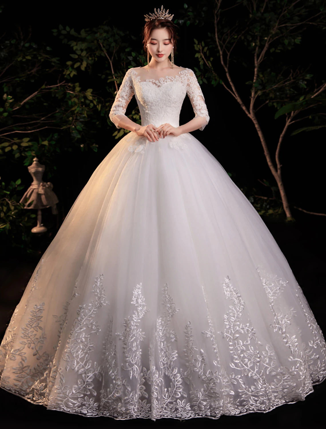 Front view of a lace ball gown wedding dress with illusion neckline and half sleeves.